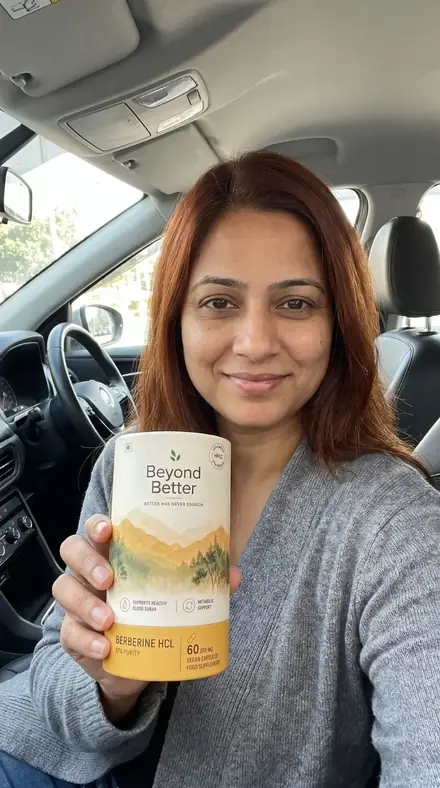 A woman in a car holding the Beyond Better berberine tub